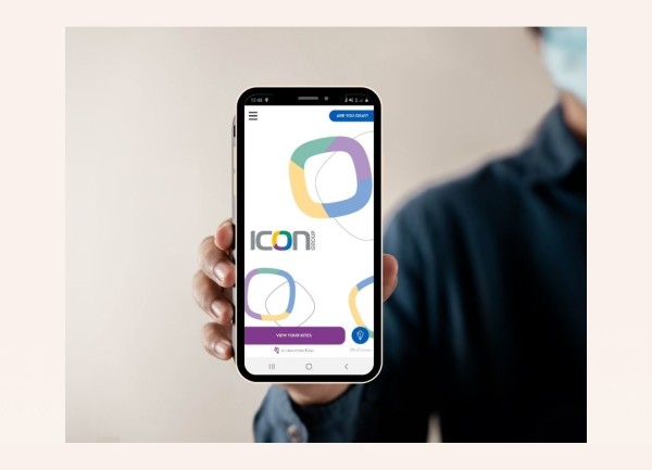 Someone holding a phone displaying the Icon Group branded Kite app